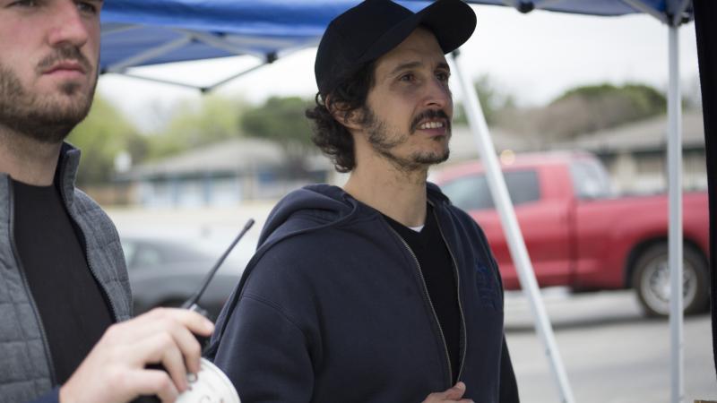 A photo of two bearded men who are looking away from the camera.