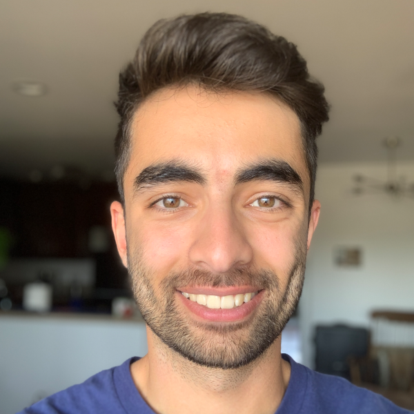 Filmmaker Tomer Keysar is a middle aged man with dark brown hair, wearing a blue shirt and smiling at the camera. 