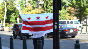 Man holding DC Flag up.