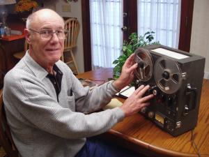 Promotional still. Norm Oberst displays a 1960's era audio playback device.