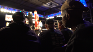 The audience watches Alejandro fight in the ring.