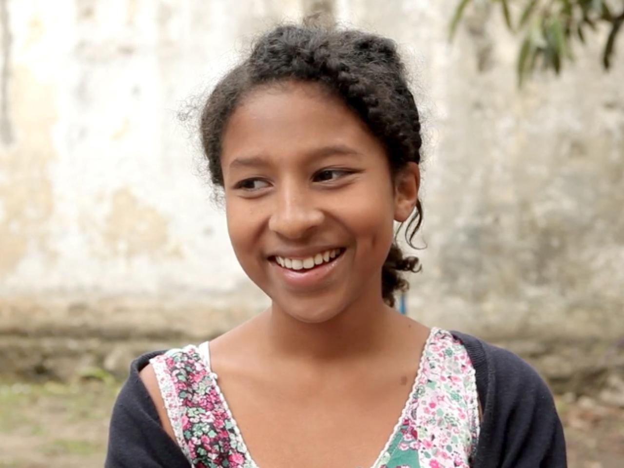 Young girl smiles and looks off camera