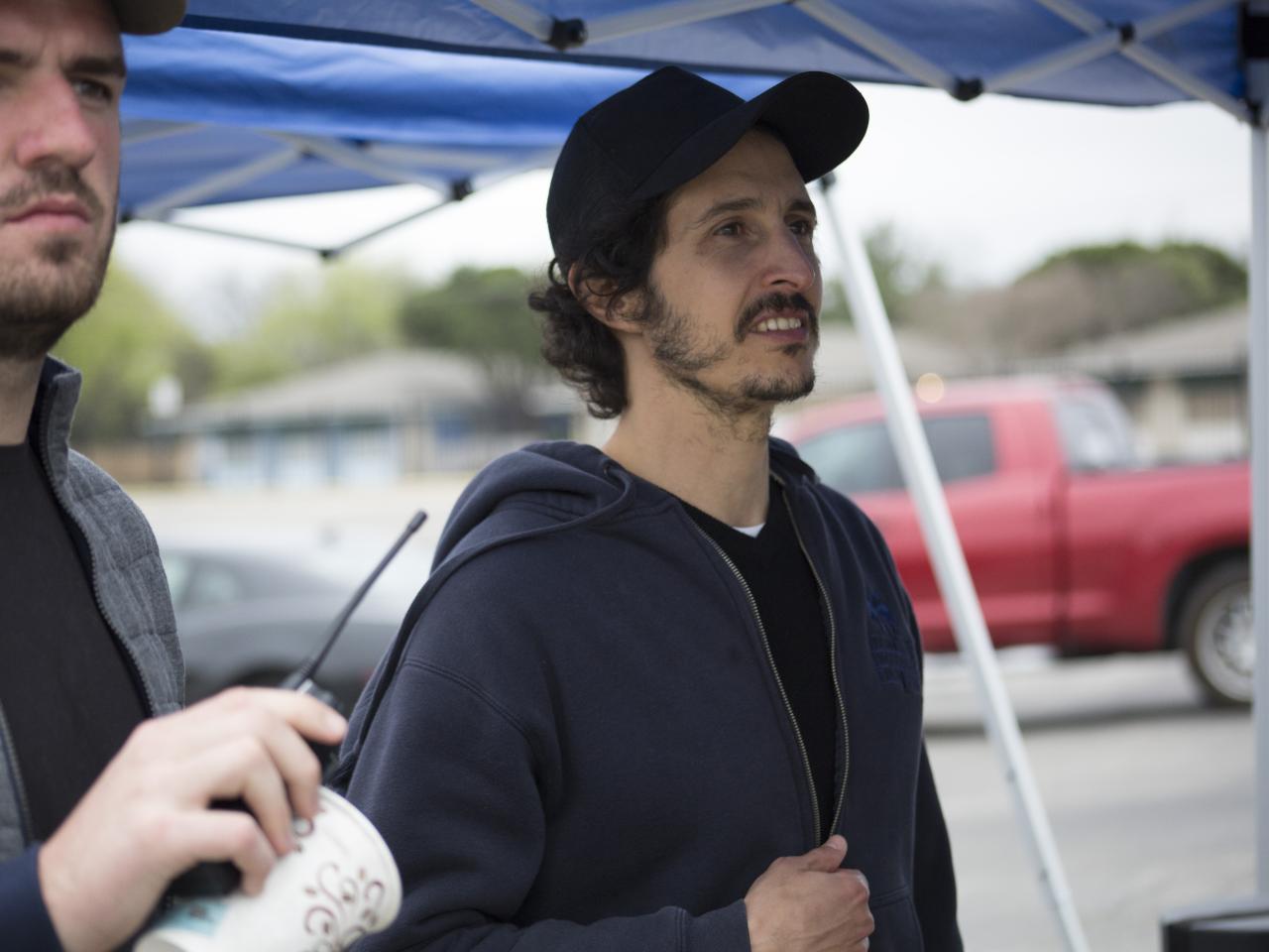 A photo of two bearded men who are looking away from the camera.