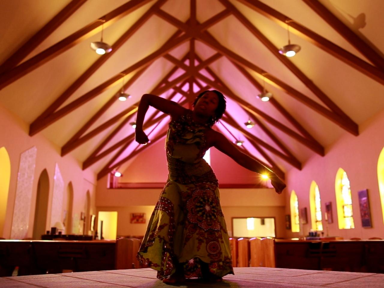 Gigi dances in center of open church