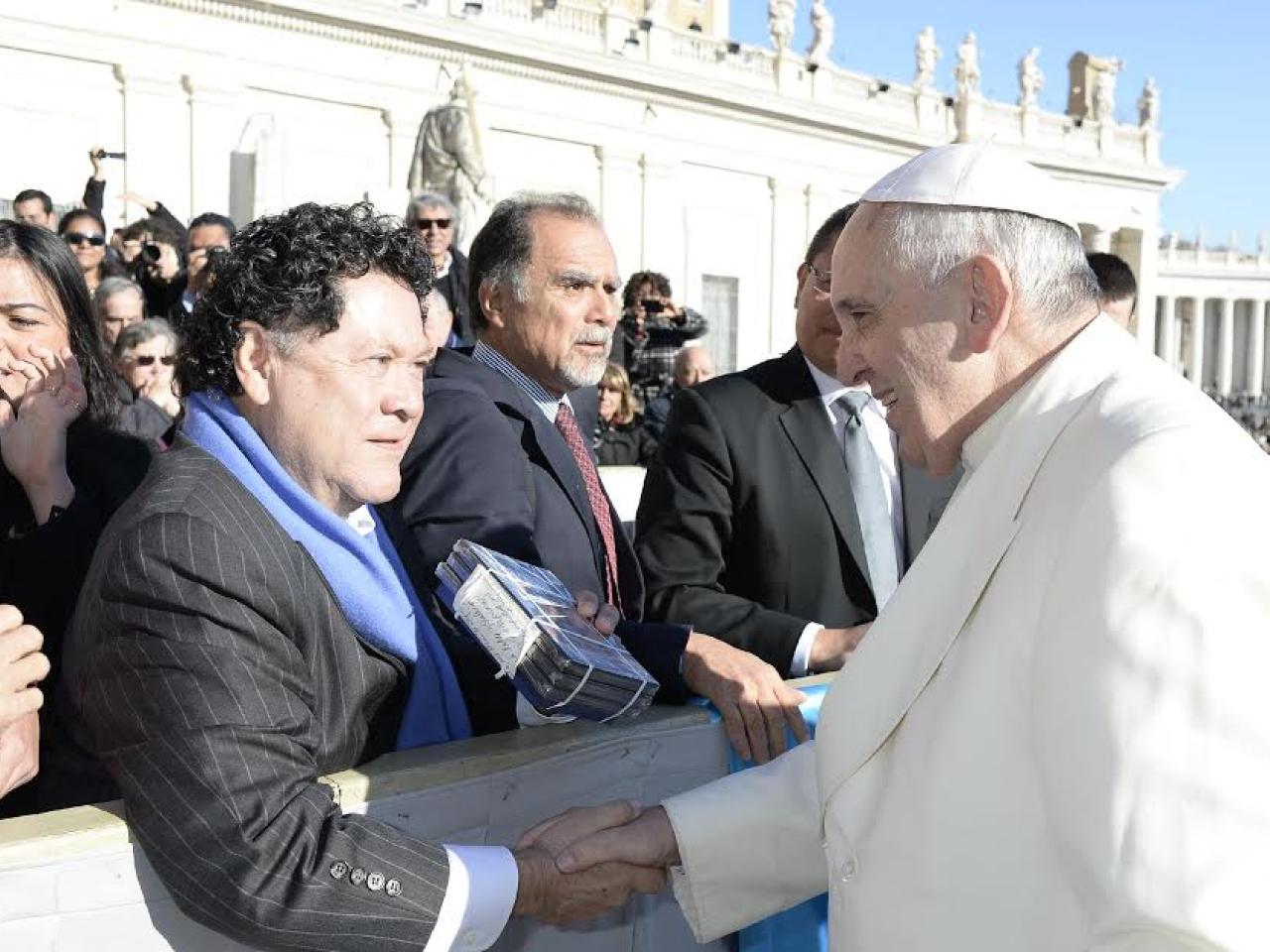 Filmmaker Luis Argueta hands Pope Francis DVDs of his documentary, abUSed: The Postville Raid.